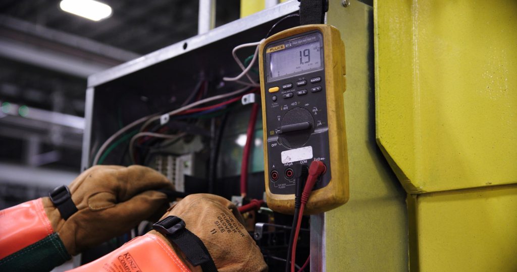 Elektriker misst mit einem Multimeter an einem Schaltschrank