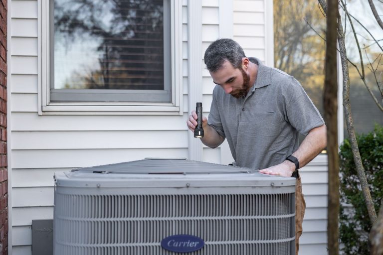 Techniker prüft das Außengerät einer Klimaanlage am Haus